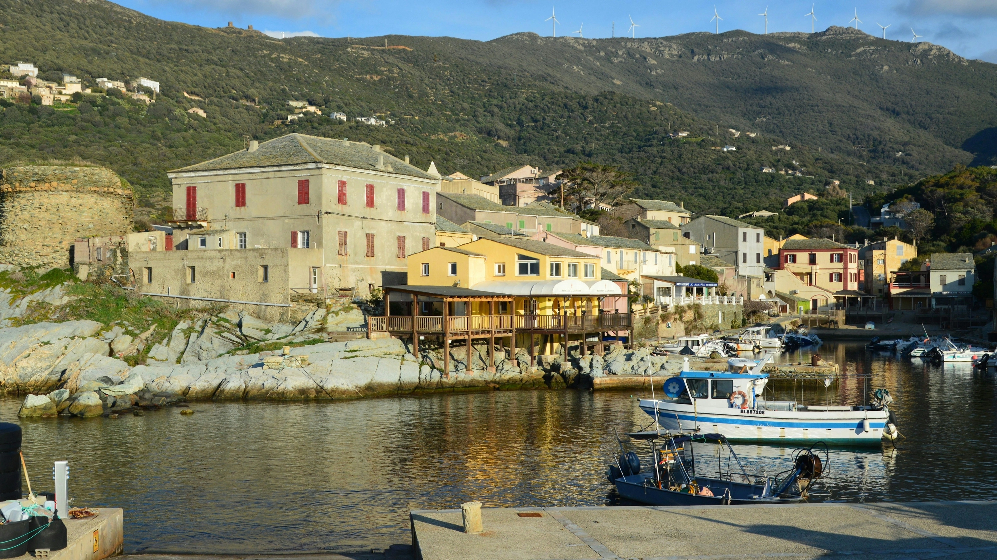 Village du Cap Corse avec éoliennes sur la crête