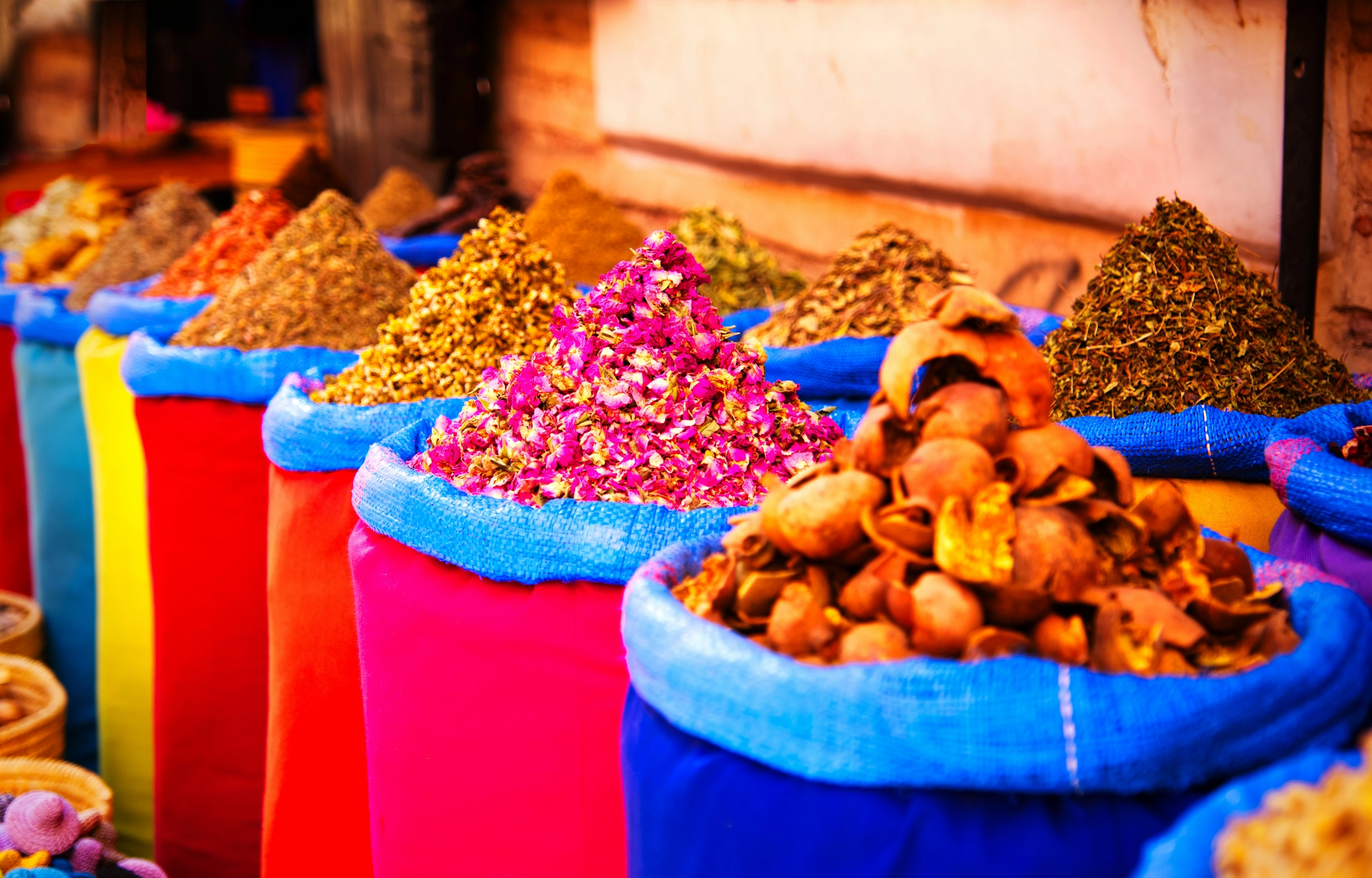 Sacs colorés d'épices et de fleurs séchées dans un souk de Marrakech
