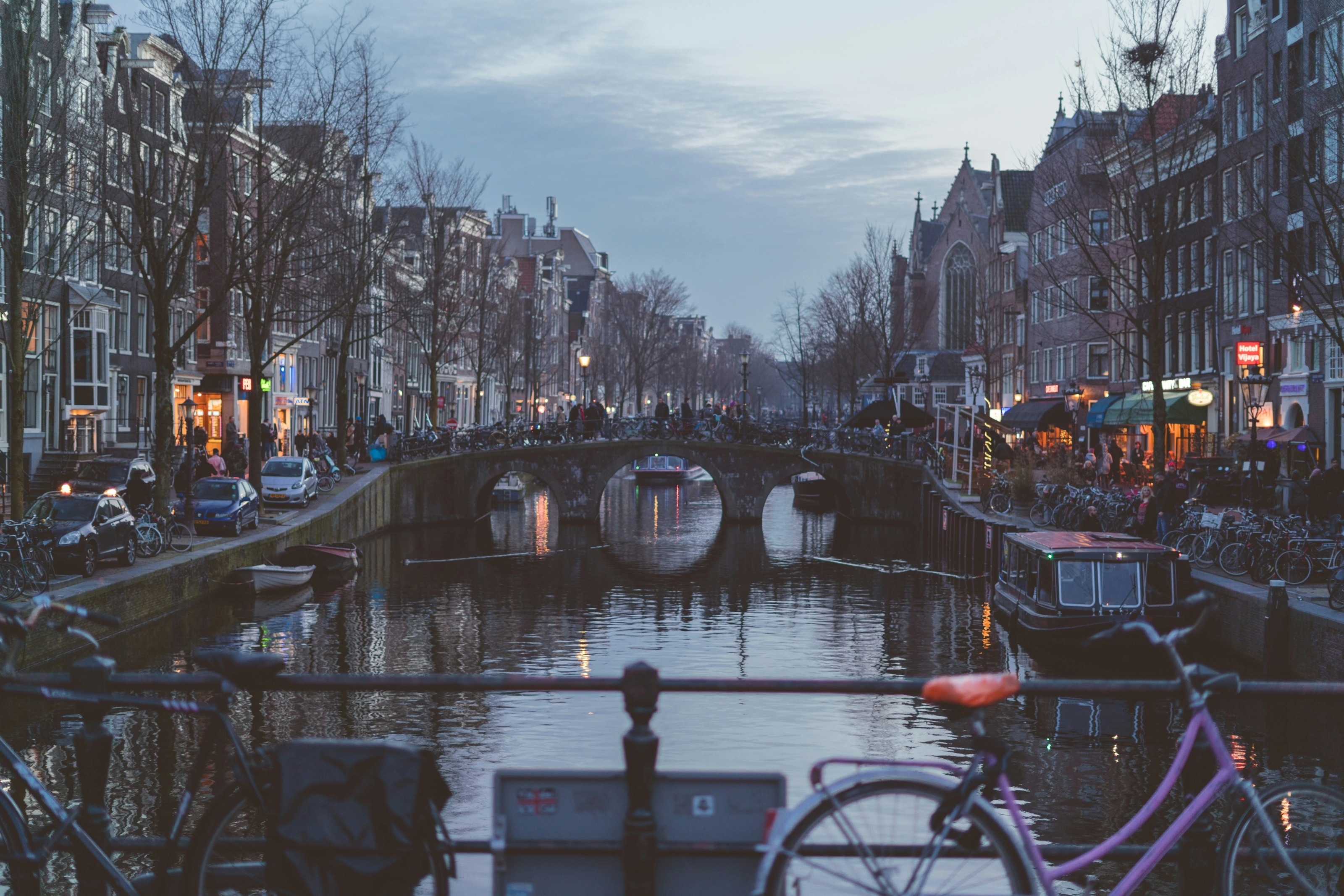 Canal d'Amsterdam à la tombée de la nuit avec ses péniches