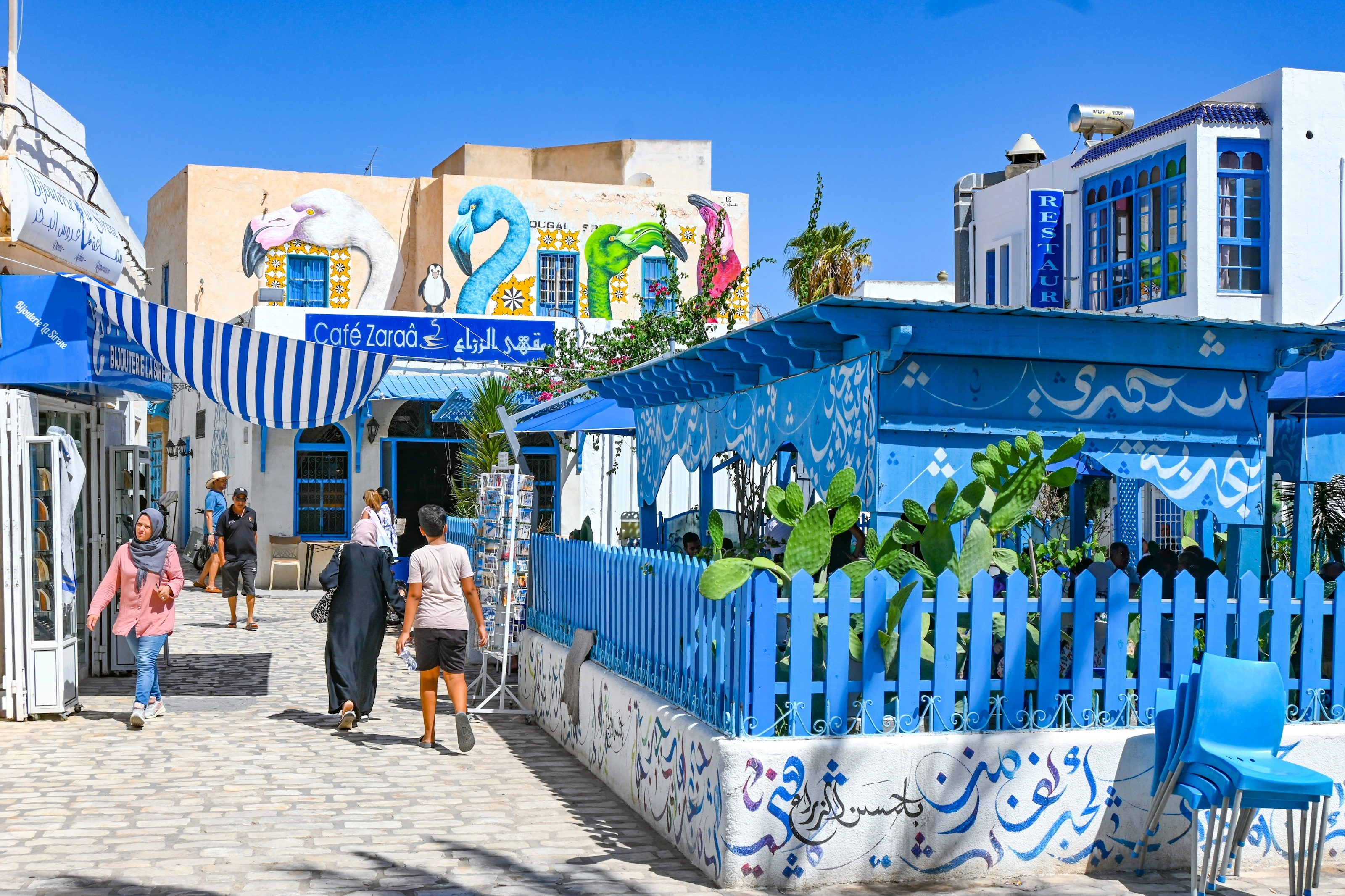 Rue animée de La Goulette, cafés et façades bleues