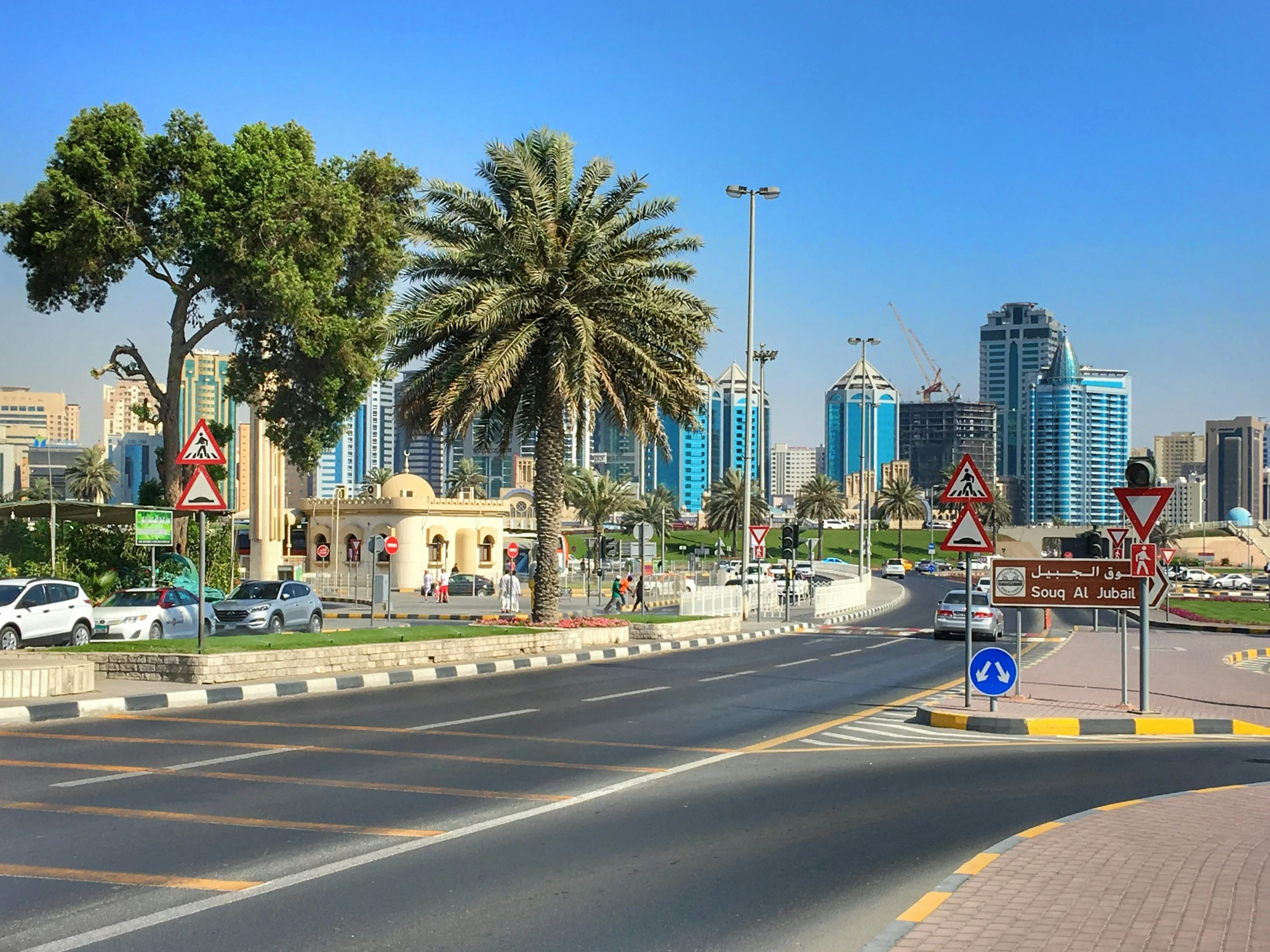 Straßenszene mit Palme und Skyline nahe dem Souq Al Jubail in Sharjah