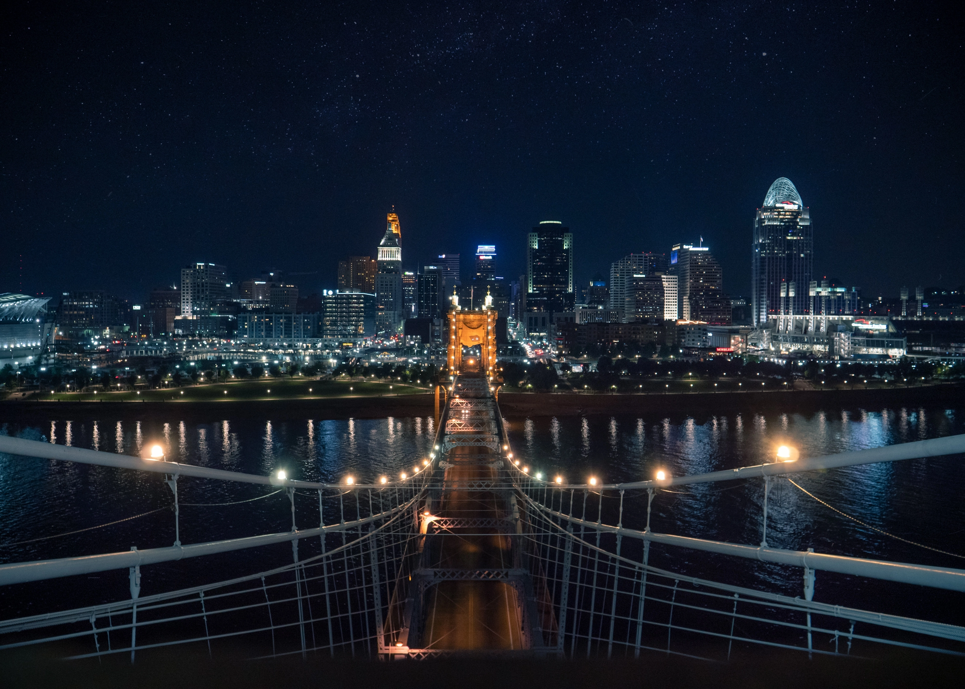 Pont Roebling illuminé la nuit face au skyline de Cincinnati